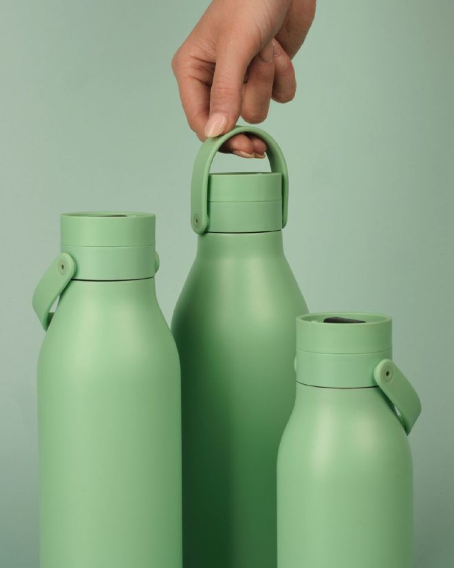 reusable coffee cup mustard yellow lid in the snow